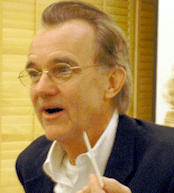 Poor-resolution, slightly blurry picture of Edward Tufte, taken while signing books at the Stanford talk.  He's talking, holding up a pen.