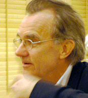Tufte turned slightly sideways.  His hand is blurry with motion in front of his face.